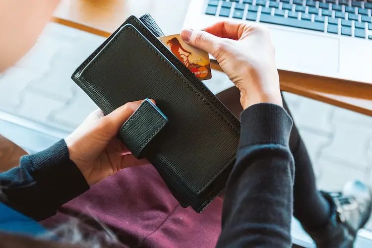 How to build credit: person getting a credit card from a wallet