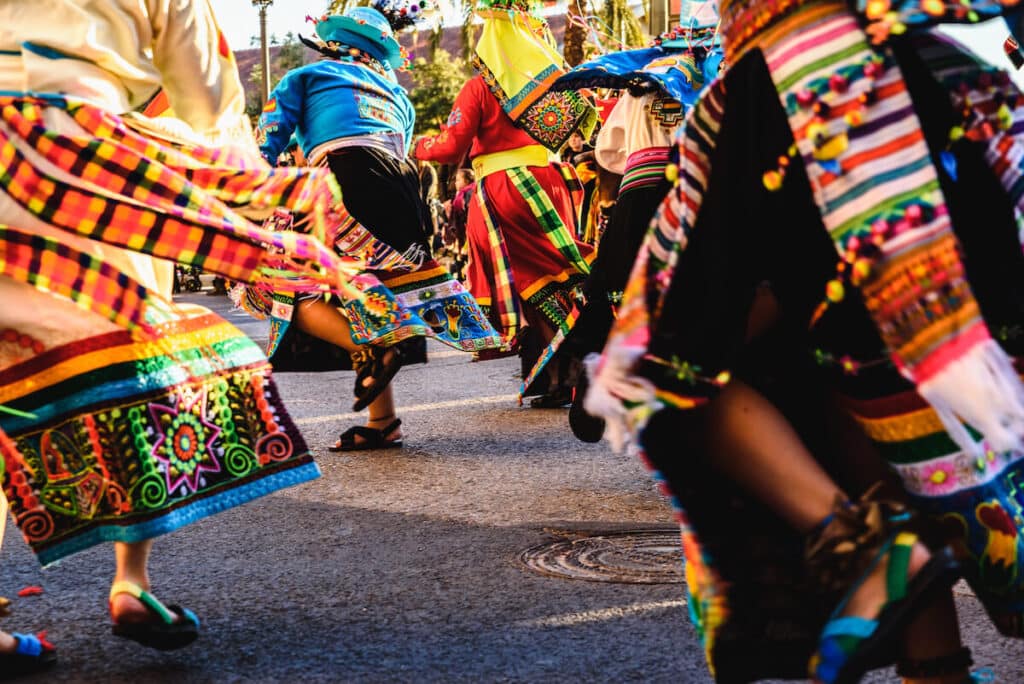 Latin America holidays: people in colorful outfits dancing in the street
