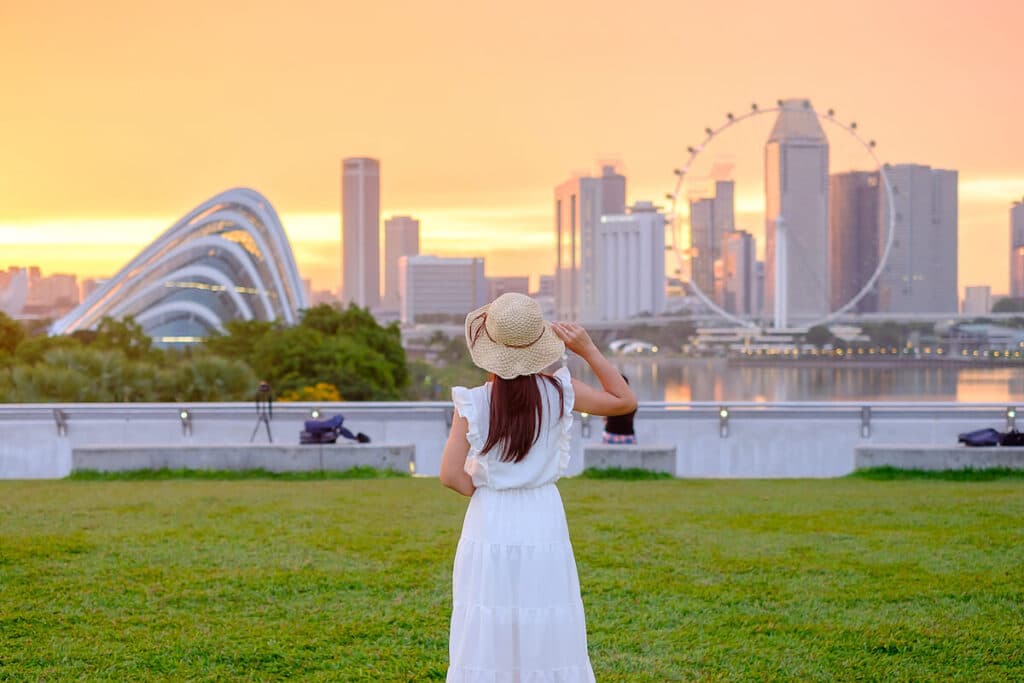 What is Alipay: woman wearing a sunhat, looking at Singapore City's buildings