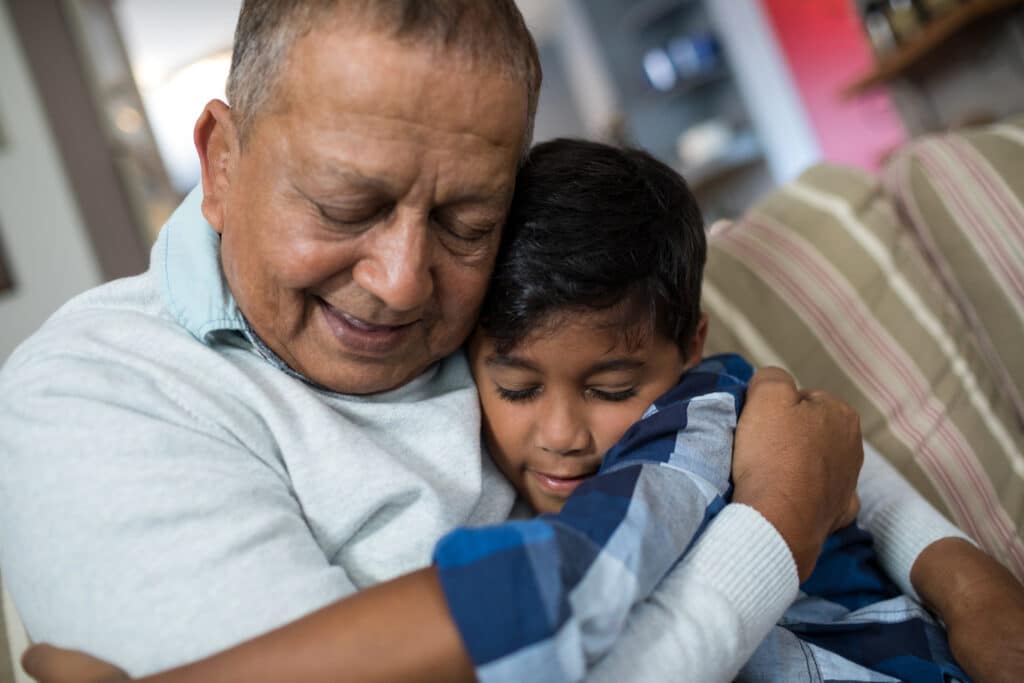 paying lower international money transfer fees means more money gets home to family like this grandfather hugging his grandson