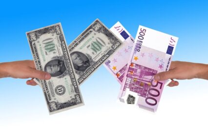 exchange rates are illustrated in this photo showing dollars to euros in two different hands