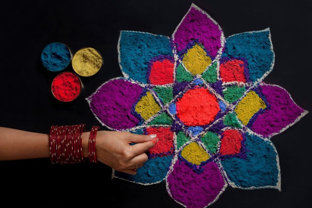 Diwali rangoli designs: person making a rangoli