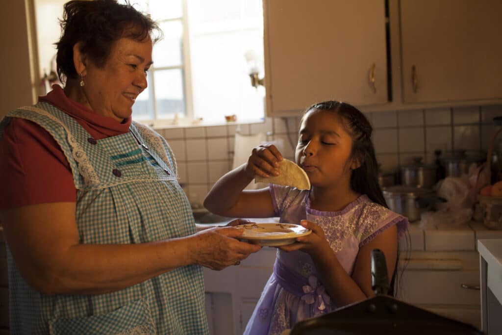 Hispanic woman making food for kids