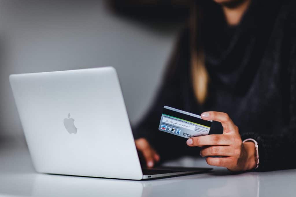 Kreditkarte erhalten: Frau mit Kreditkarte an einem Laptop
