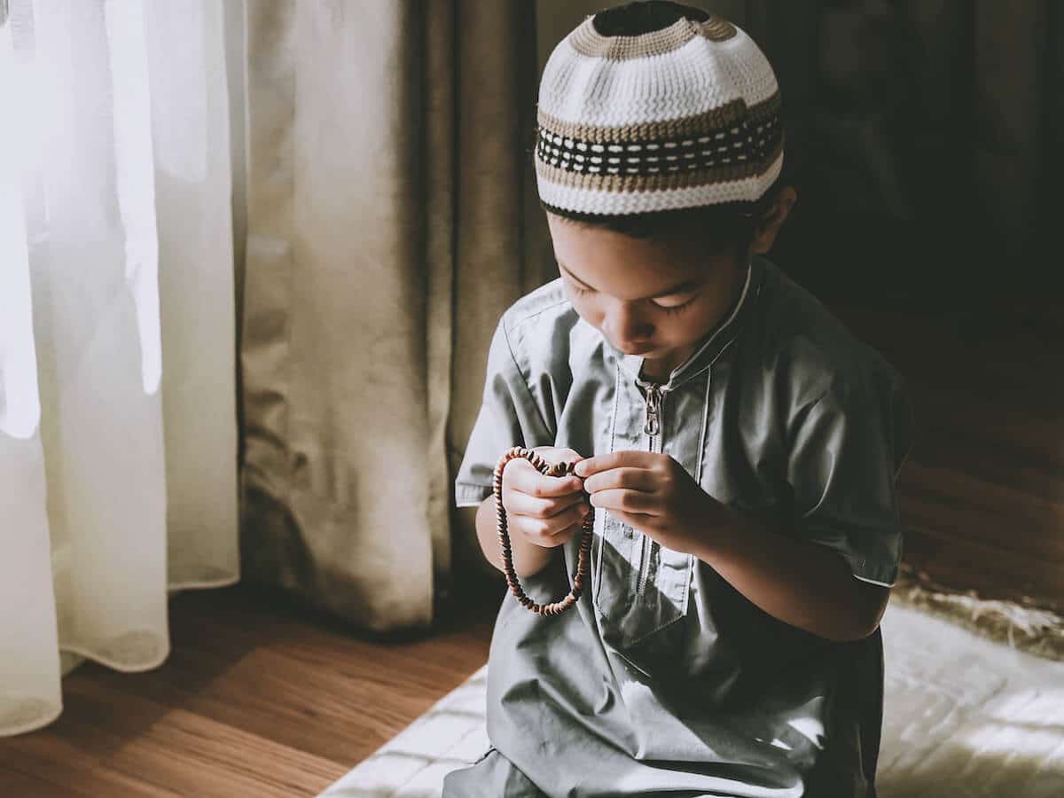 When is Eid al Adha: kid holding a misbaha