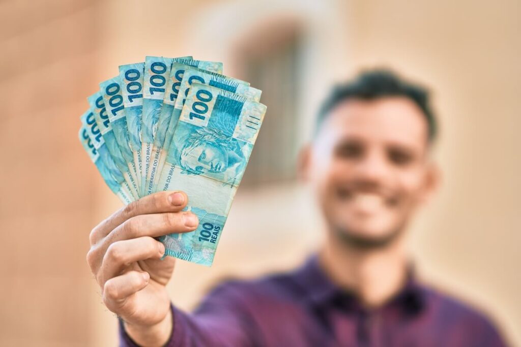 Man holding some Brazilian dollars