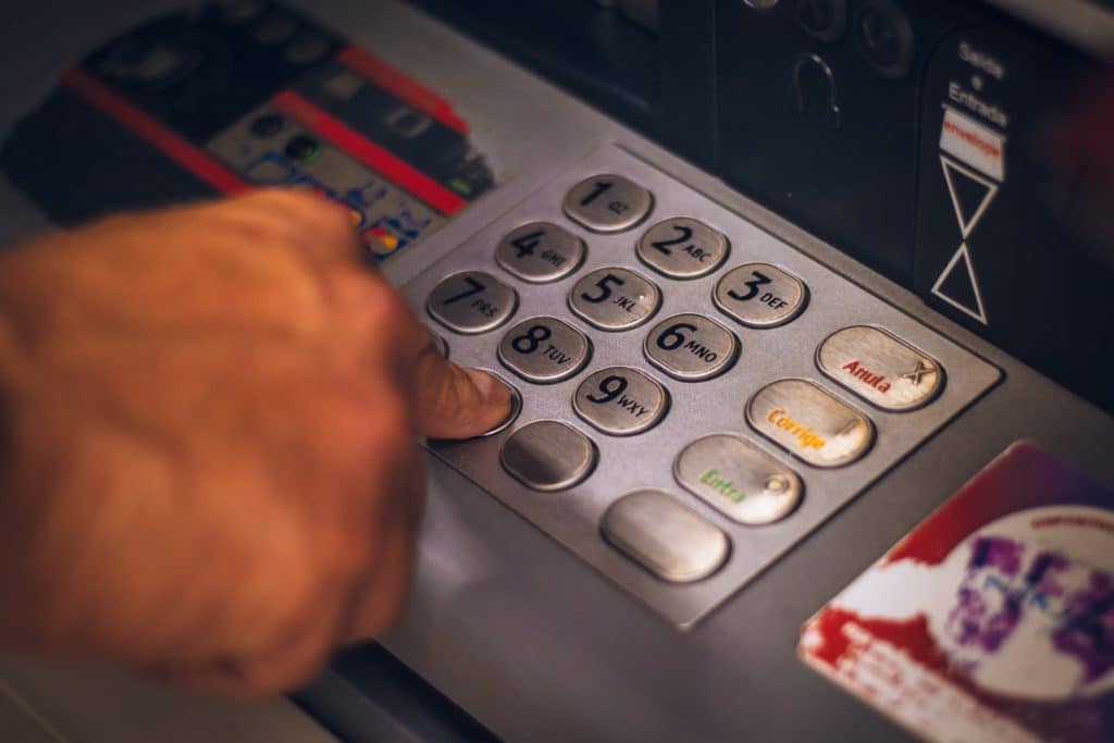 ABA-Routing-Nummer: Hand gibt etwas an Geldautomaten ein