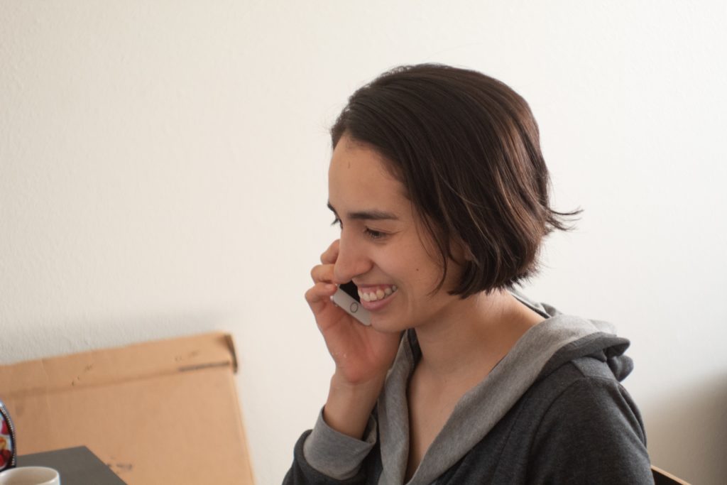 Una mujer joven sonriendo mientras habla por teléfono
