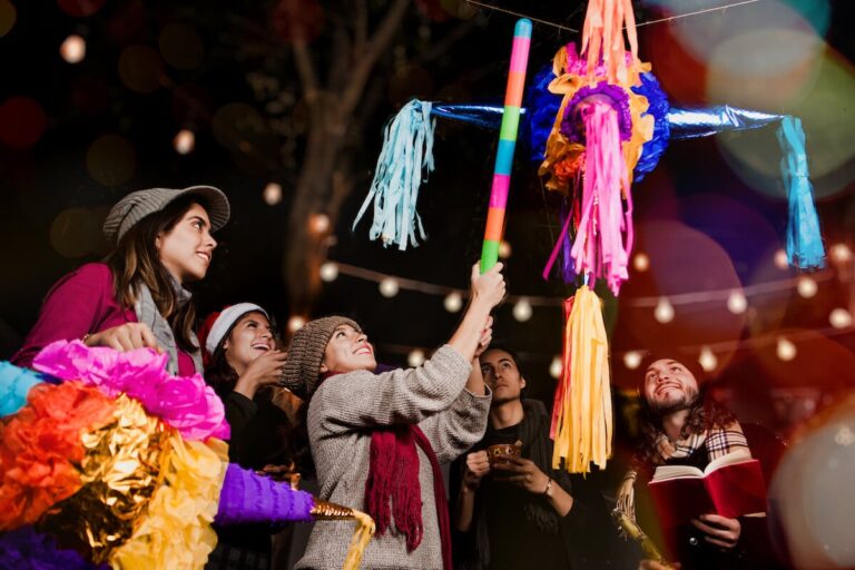Mexico holiday traditions: group of friends breaking a piñata