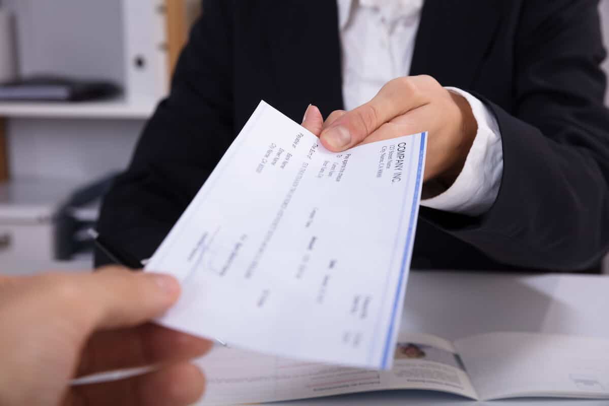 Person handing a check to a bank teller