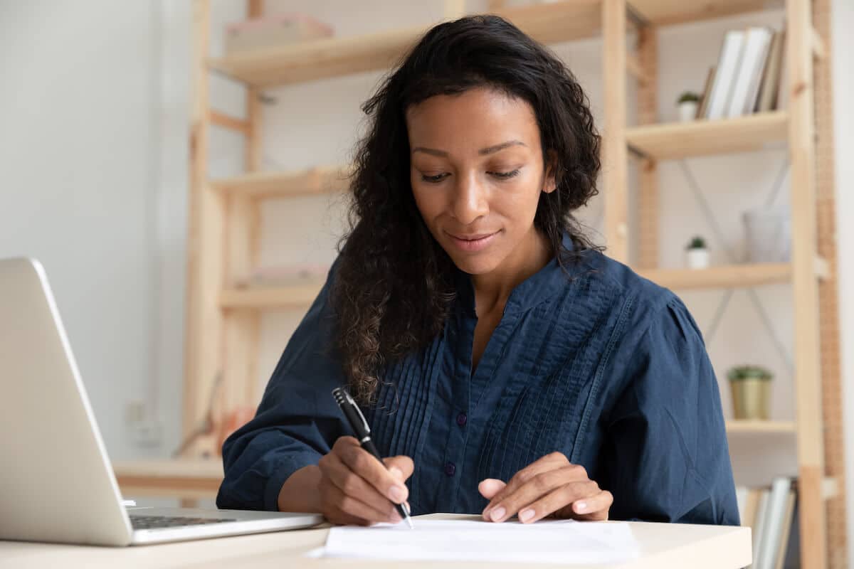How to write a check: woman writing on a piece of paper