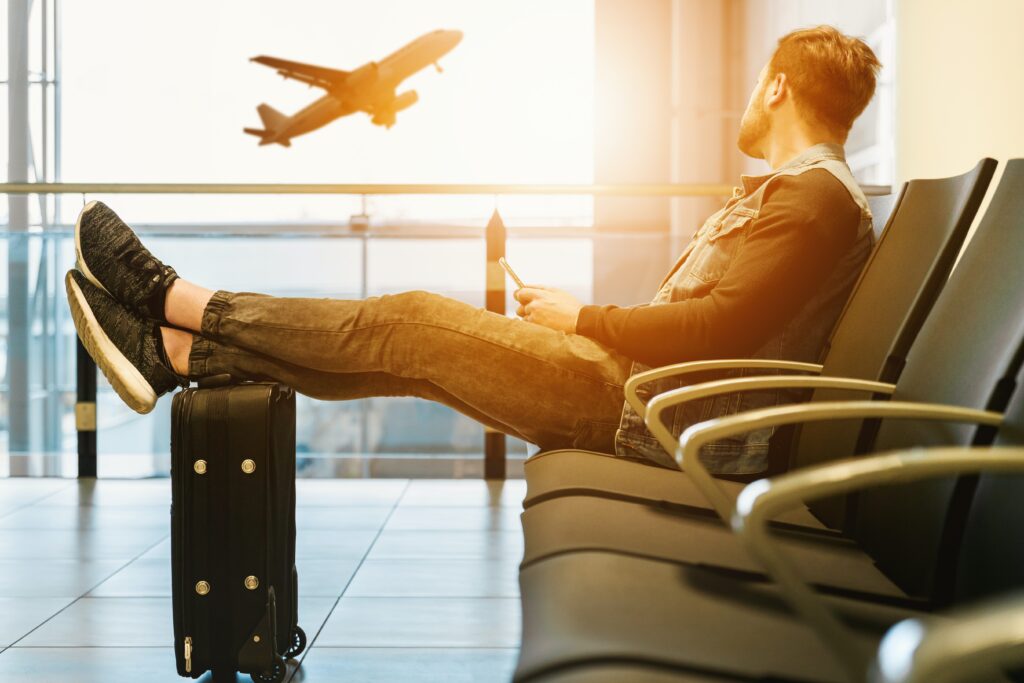 Tipps für die Suche nach Sondertarifen für internationale Flüge: Mann mit Koffer in Abflughalle