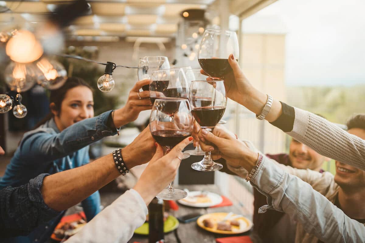 How to make friends in a new city: friends toasting with red wine
