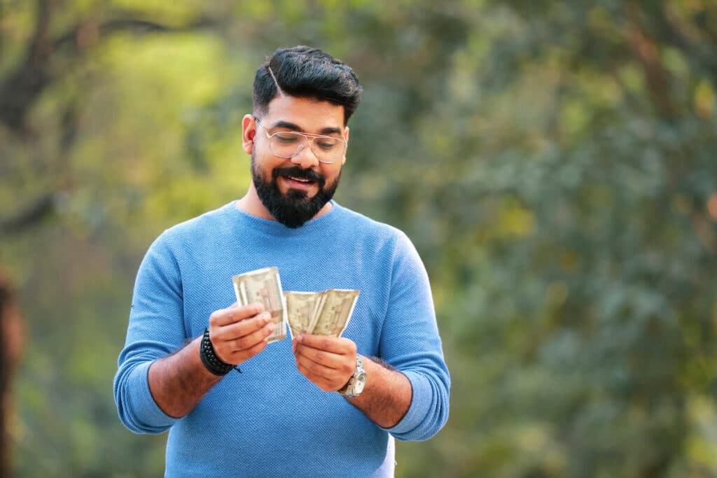 Man counting some Indian rupee bills