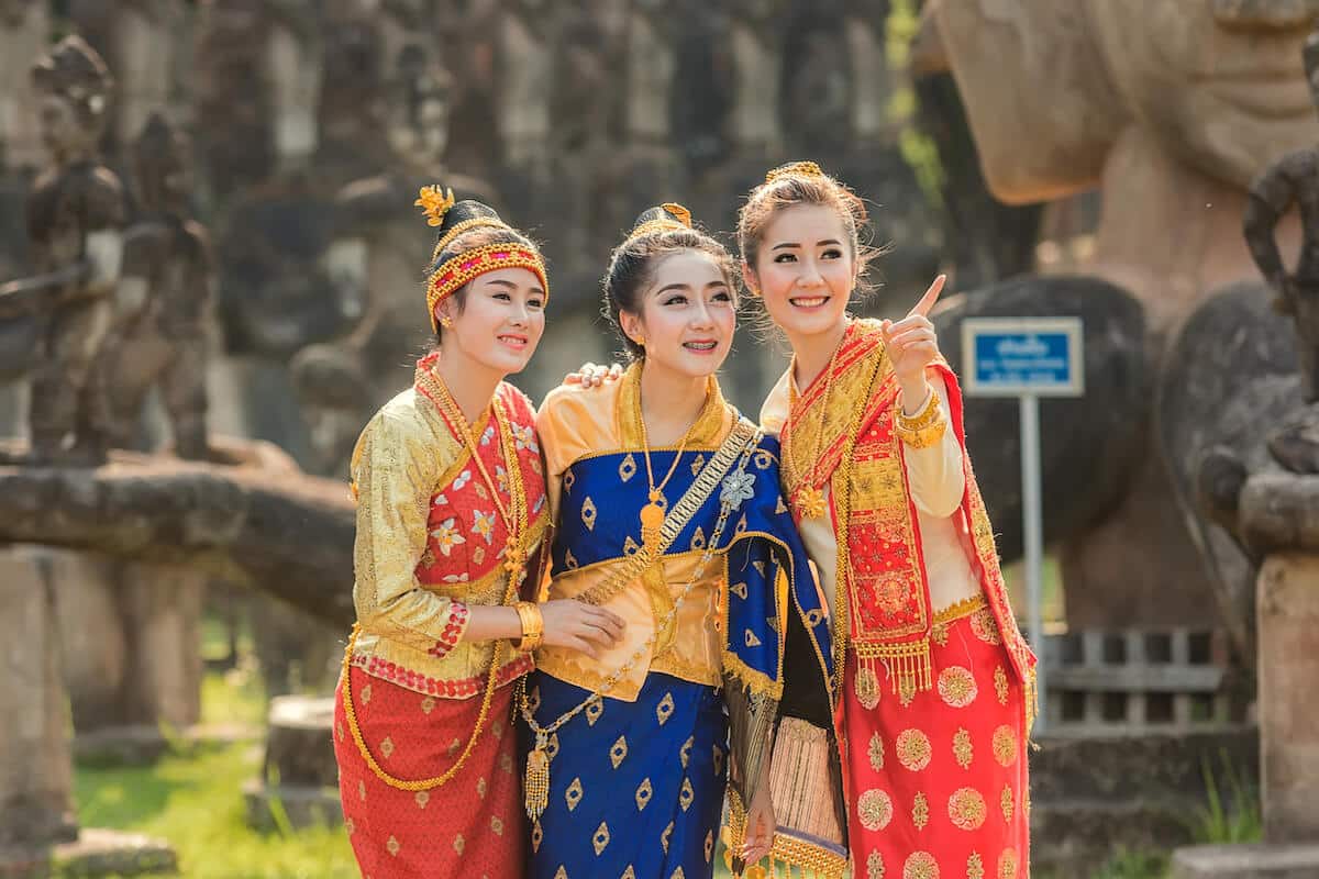Laos currency: three women wearing traditional Laos clothes
