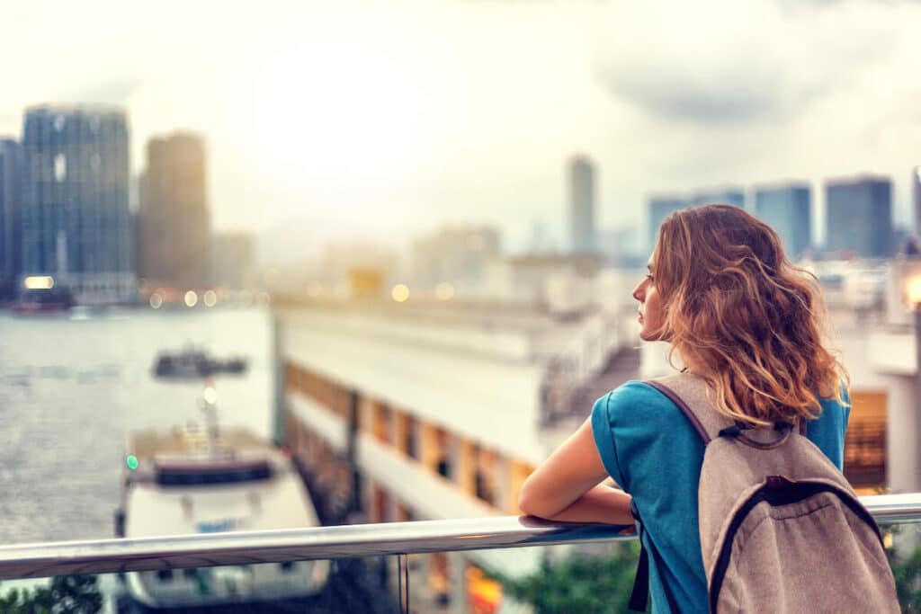 Woman with a backpack looking at a view of a city