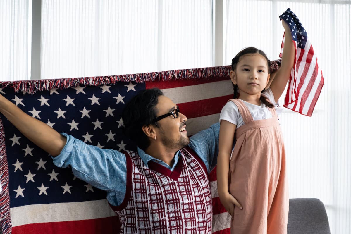 Lowest cost of living states: father and daughter holding American flags