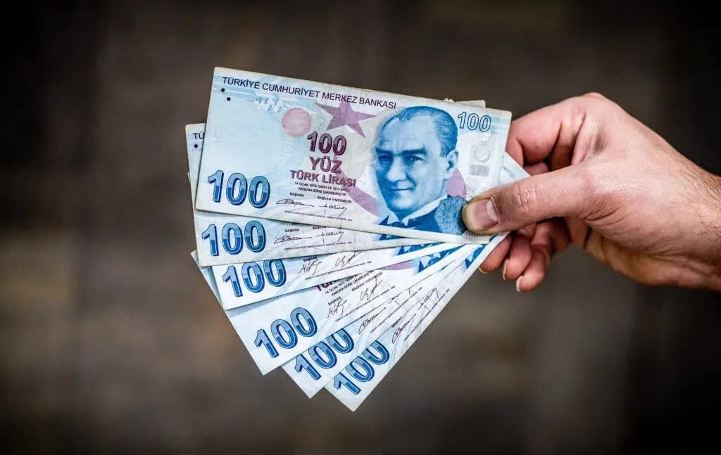 Currency in Turkey: person holding six pieces of Turkish lira banknotes