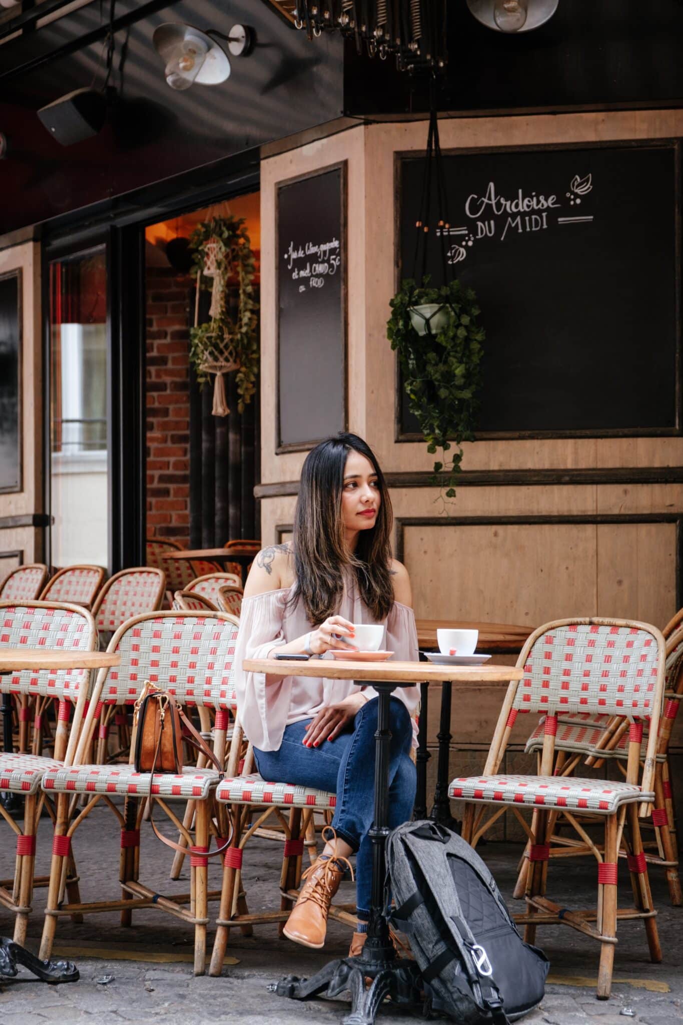 Une jeune femme assise à la terrasse d'un café français