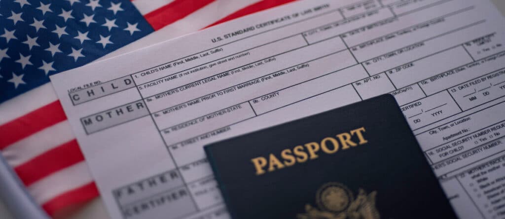 Un pasaporte y un formulario colocados en una bandera estadounidense.
