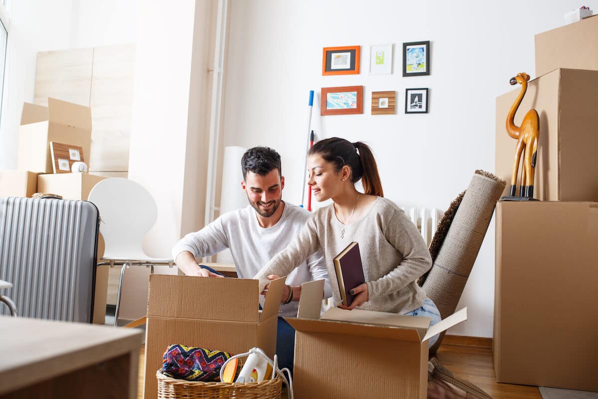 How to move to another country: couple unpacking their things in their new home