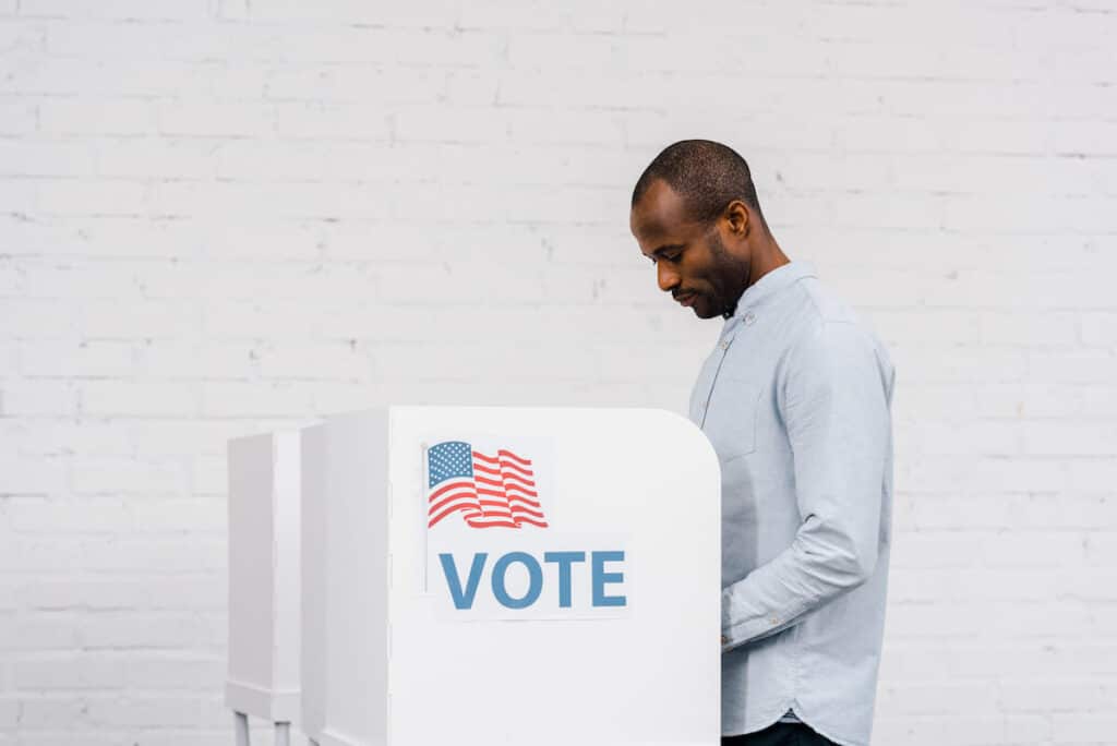 Can you vote if you have a green card: man standing and voting