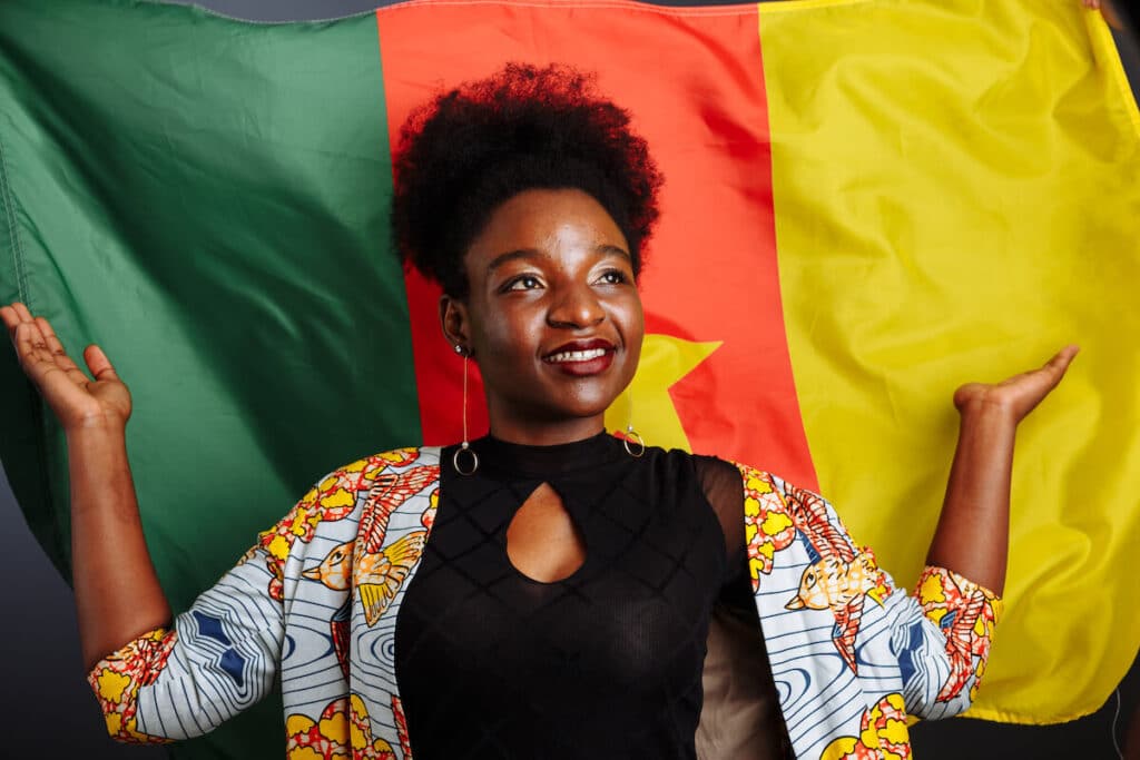 Woman looking up with the Cameroon flag in the background