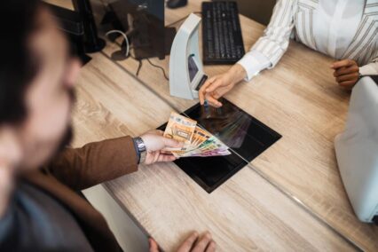 A person trades currency at an exchange counter