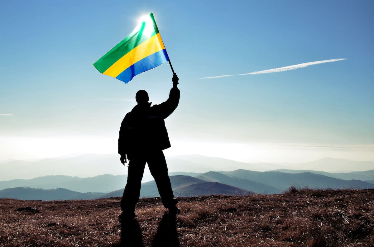 Gabon currency: A silhouette of a personal holding a Gabon flag outside