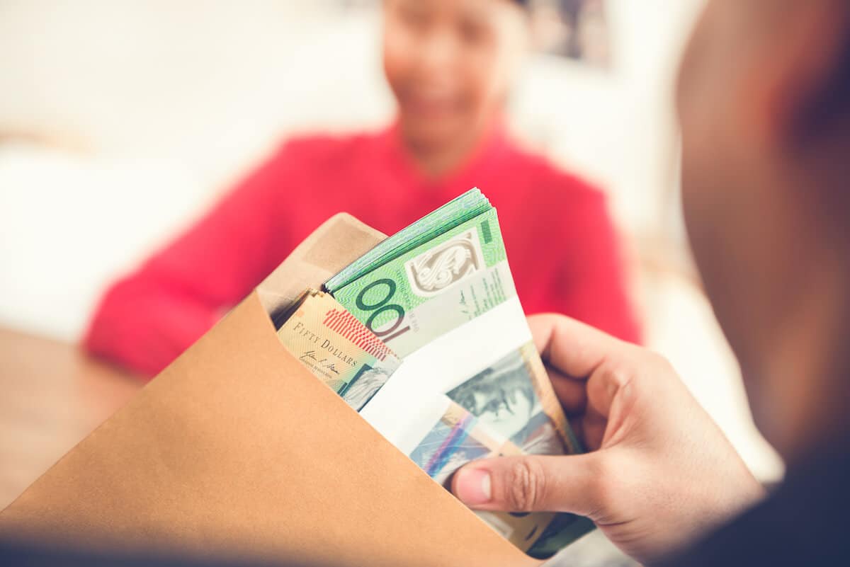 Australia work visa: person putting money into an envelope