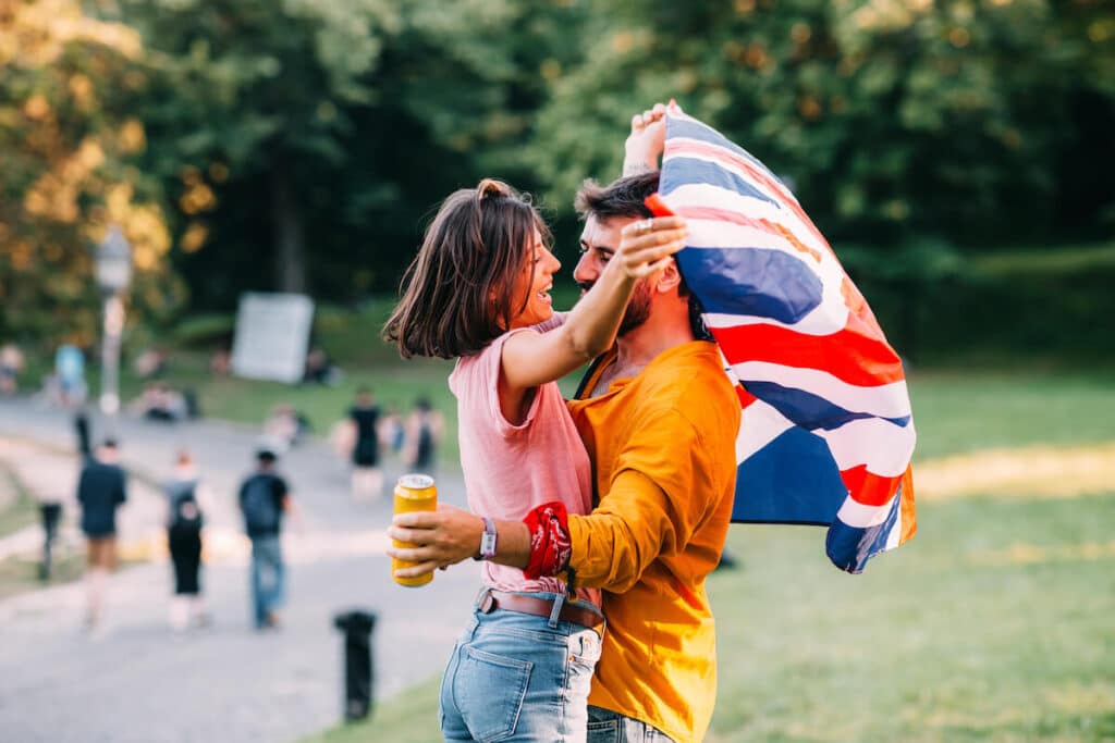 Couple holding the UK flag while hugging each other