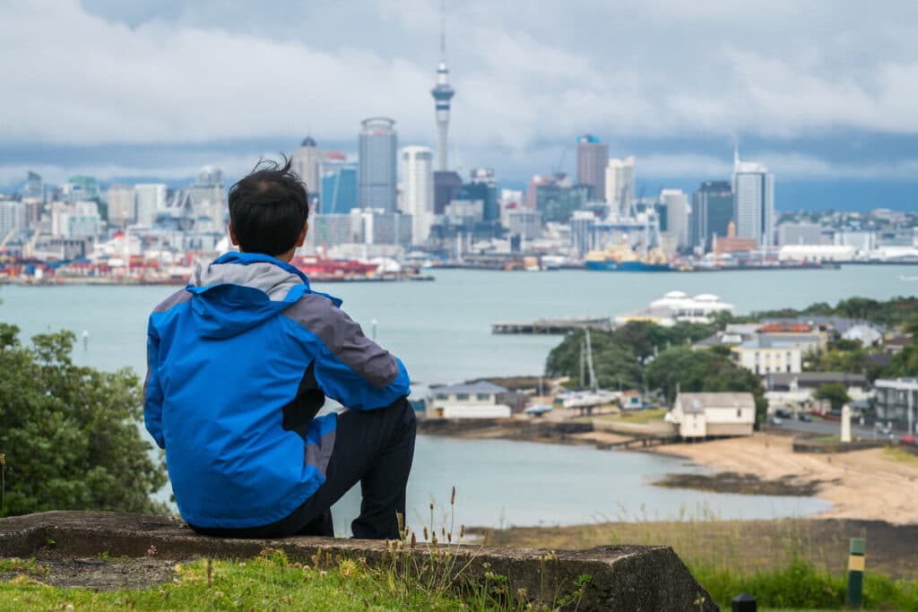 New Zealand citizenship: man looking at Auckland's city skyline