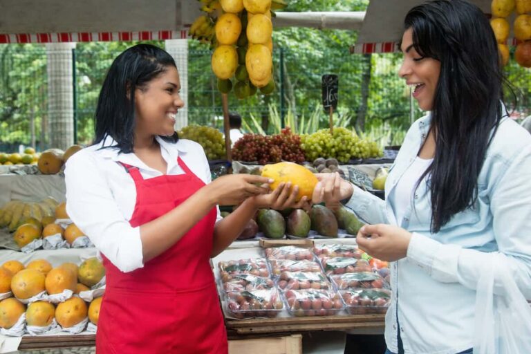 Cost of living in Costa Rica: market seller handing a fruit to a customer