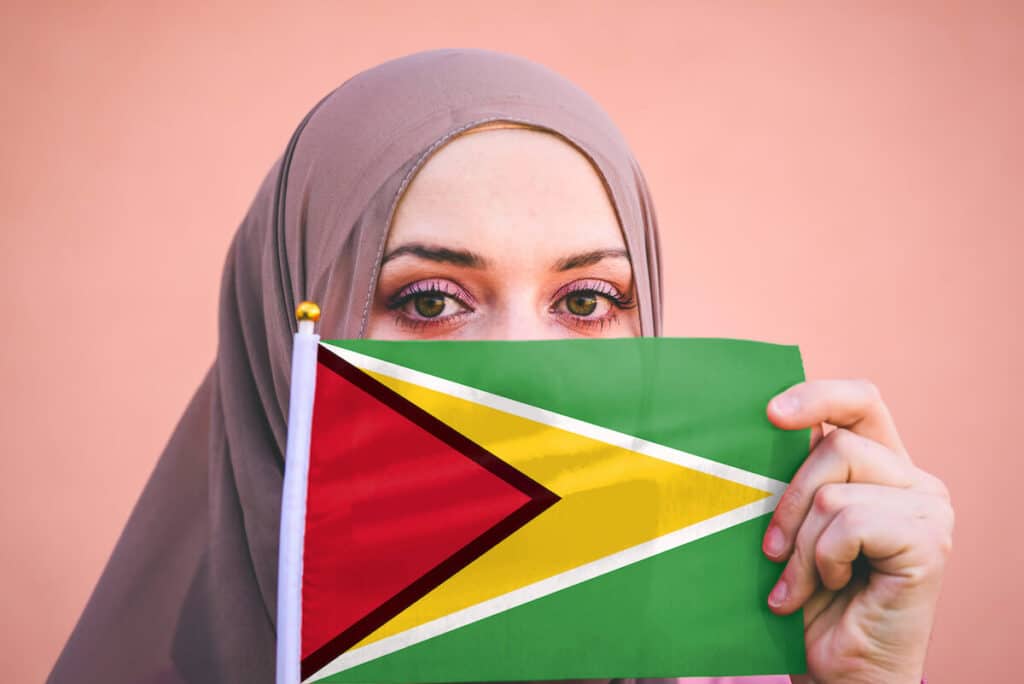 Woman covering her face with the Guyana flag