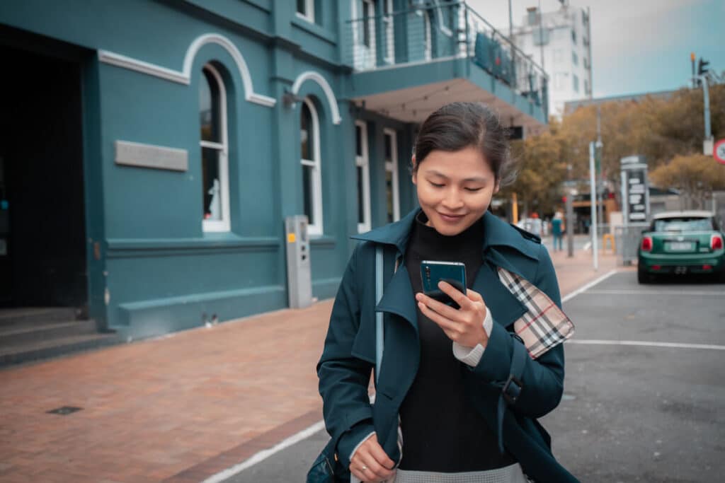 Woman using her phone while walking