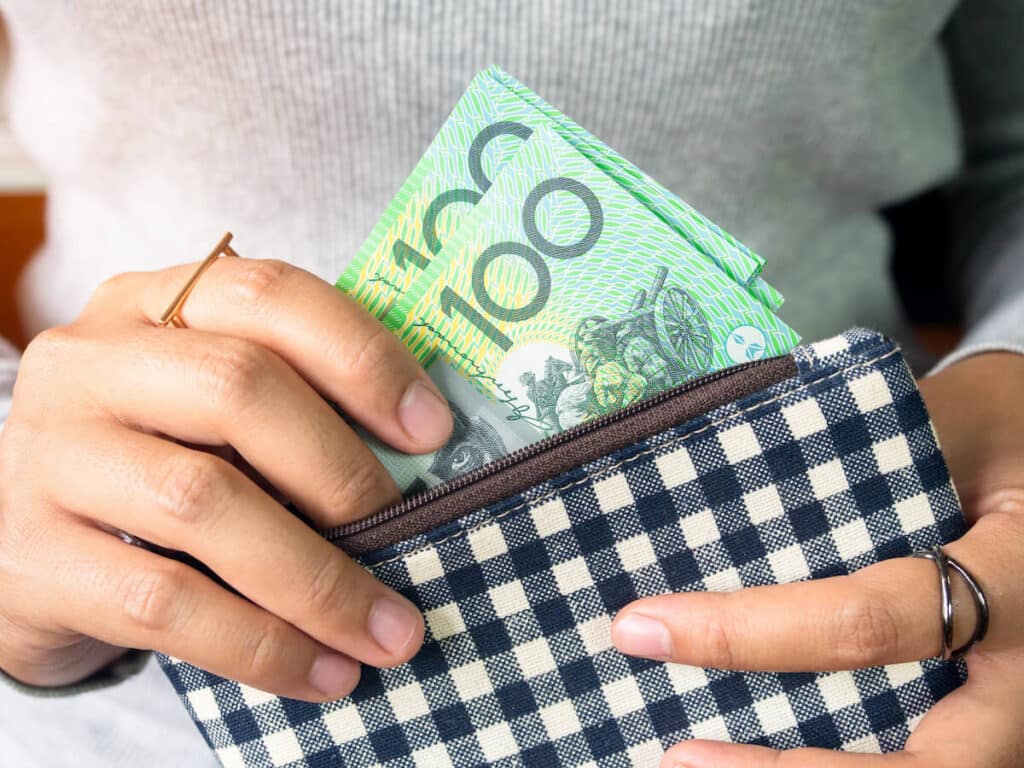 Person getting Australian currency bills from a wallet