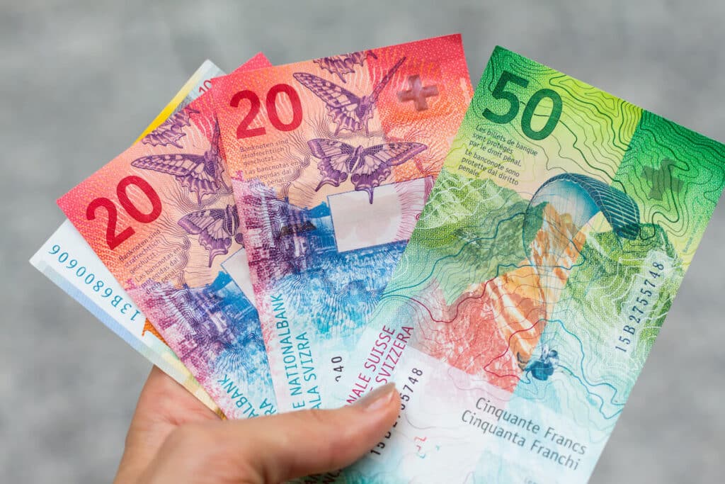 Person holding some Swiss franc bills