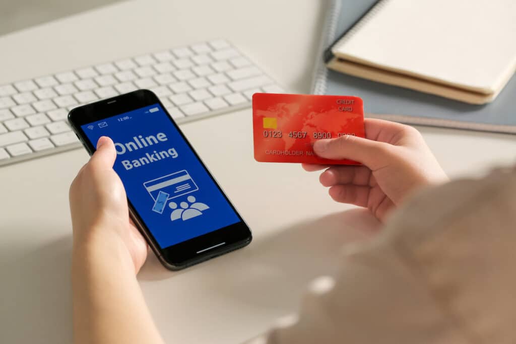 Person using a phone while holding a credit card