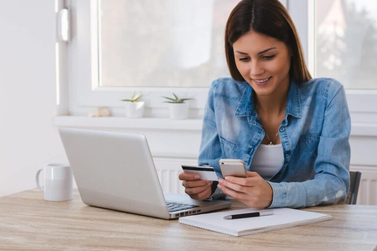 How to receive a wire transfer: woman using her phone while holding a credit card