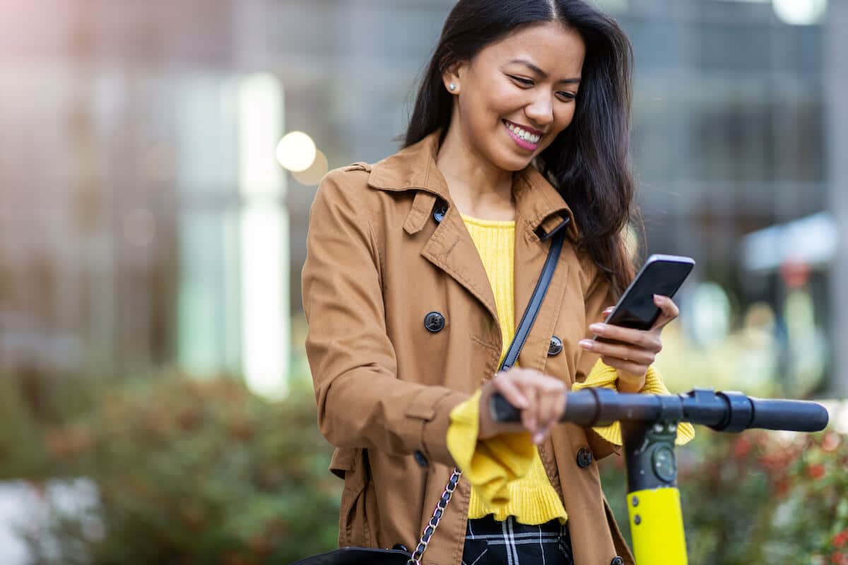 Une femme souriant en utilisant son téléphone portable