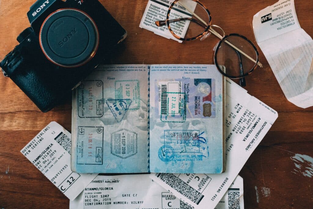 Un passeport, des cartes d'embarquement, des lunettes et un appareil photo