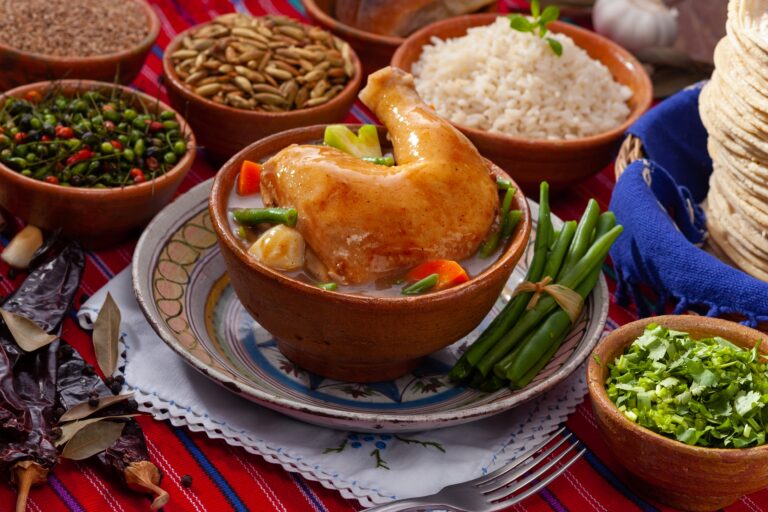 a bowl of guatemalan pepian amongst assorted other dishes