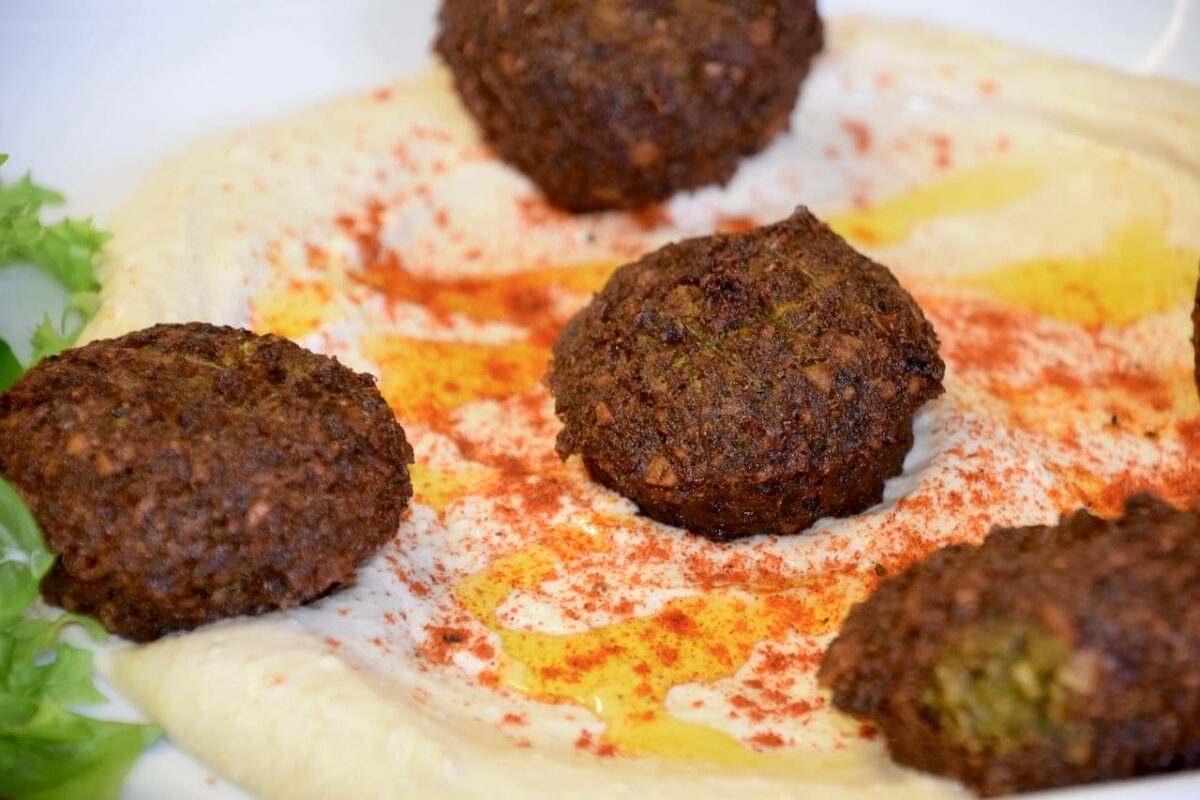 4 pieces of falafel piled on top of hummus