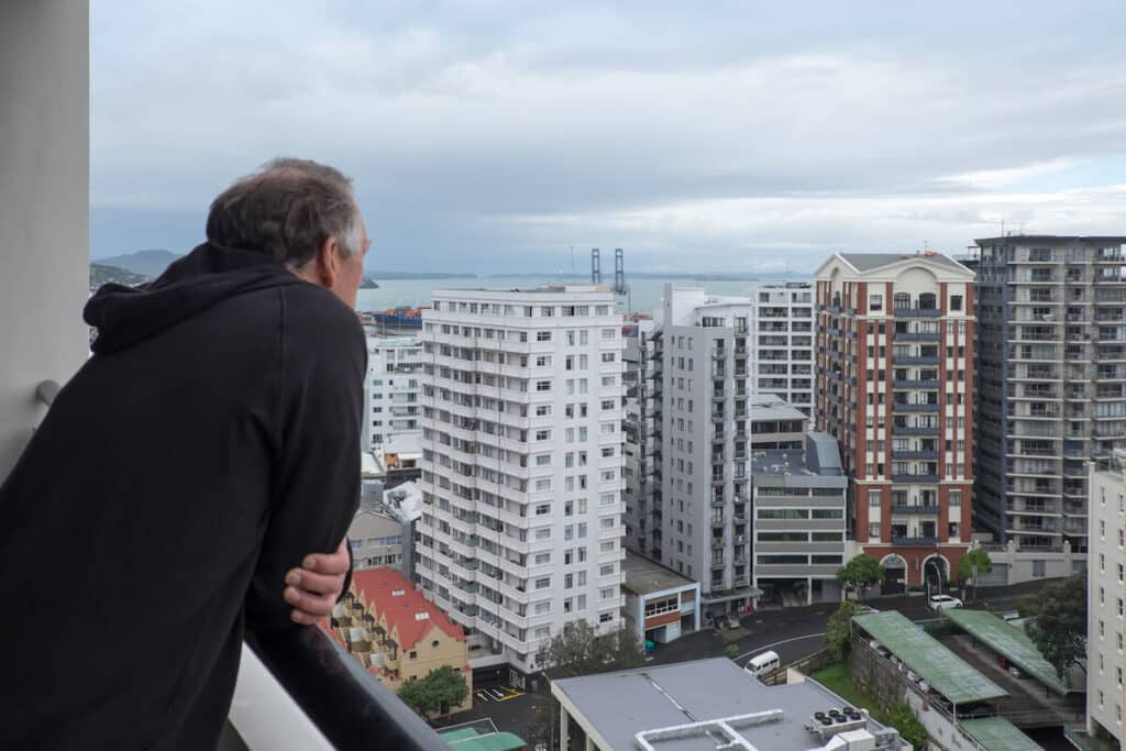 Un homme regardant les bâtiments de son balcon en hauteur