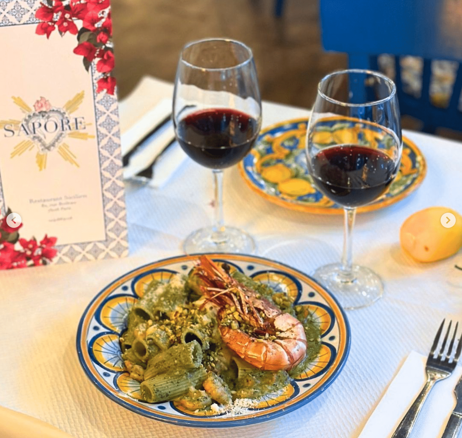 Une table avec un plat et deux verre de vin du restaurant Sapore, à Paris