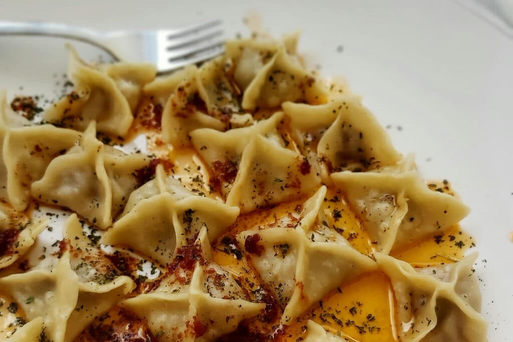 Manti dumplings on a white plate