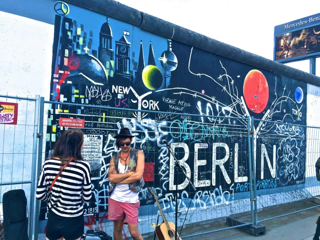 Man standing near a mural in Berlin