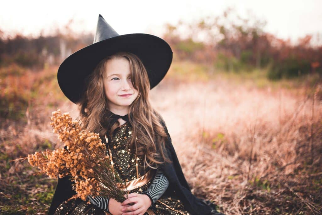 young girl dressed in a halloween costume as a witch