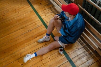 gym teacher sitting down on the gym floor