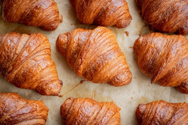 Croissants lined up on baking sheet